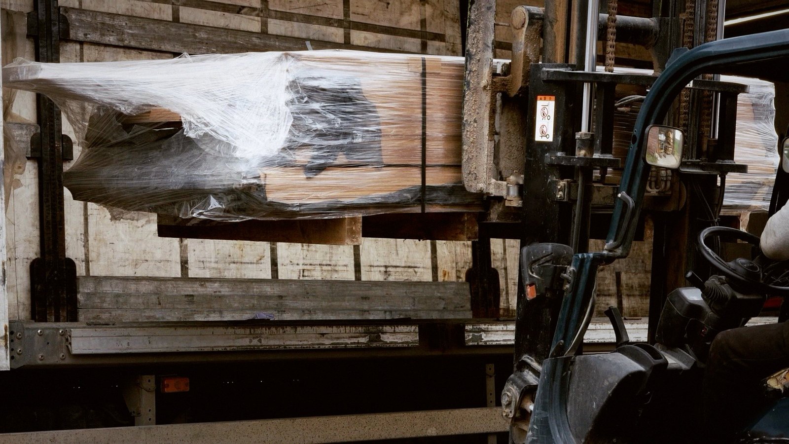 A forklift loads wrapped packs of SILVEN boards for shipping