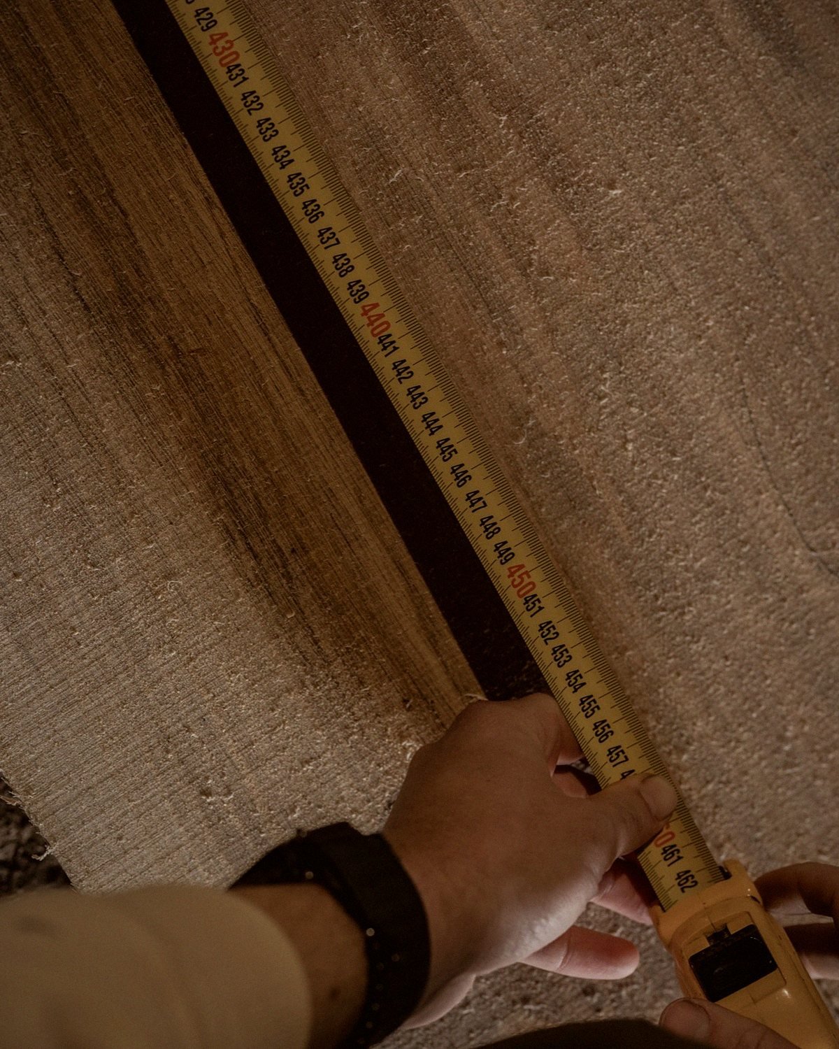 A measuring tape checks the width of an oak board