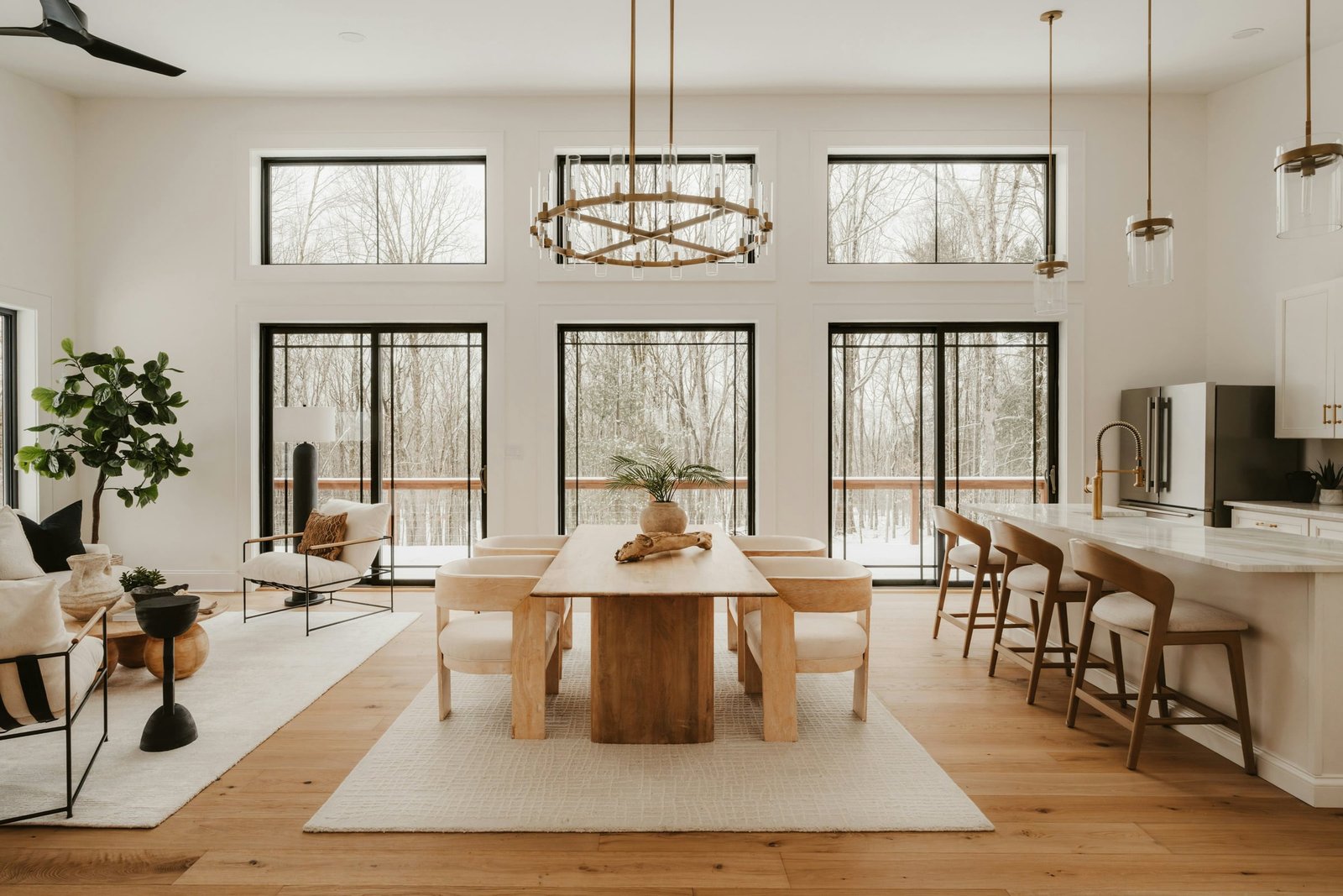 A light, spacious dining room with tall windows, natural wood floors and neutral furnishings